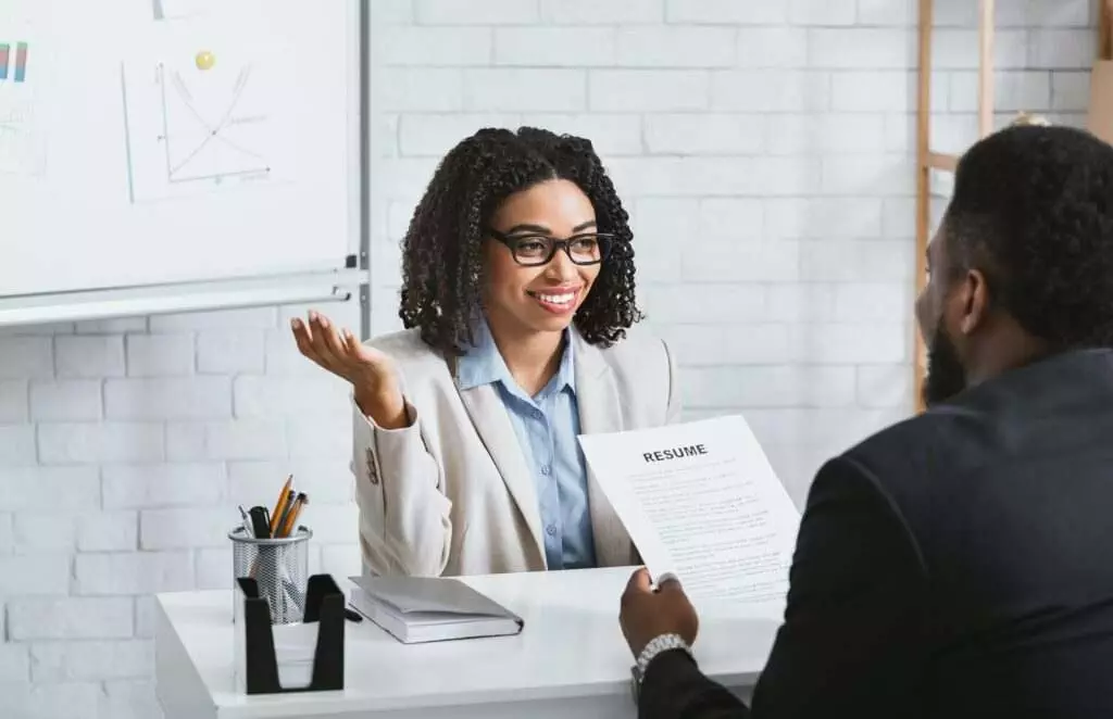 Friendly personnel manager interviewing black candidate during job interview at modern office